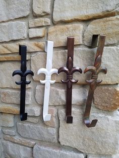 three wrought iron fleurces mounted to a stone wall