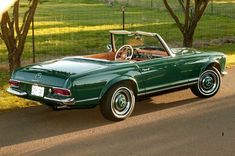 a green convertible car parked on the side of the road