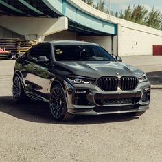 a grey bmw suv parked in front of a building