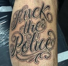 a man's leg with the words, flickk the police tattooed on it