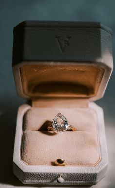 an open ring box with a diamond in it