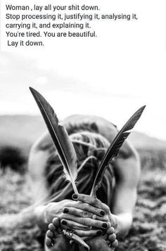 a woman laying on the ground with her hands holding two large scissors and writing something in front of her