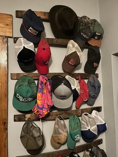 several hats are hanging on a wooden rack