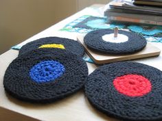 three crocheted coasters sitting on top of a table next to a stack of books