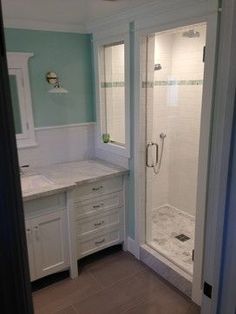 a bathroom with a walk in shower next to a sink