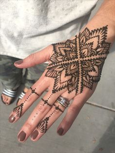 a woman's hand with henna tattoos on it