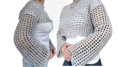 two women wearing crocheted sweaters and one has her hands on her hips