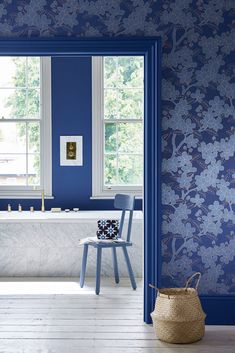 a bathroom with blue walls and white flooring, along with a bathtub in the corner