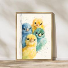 three little chicks sitting next to each other on top of a wooden table in front of a white wall