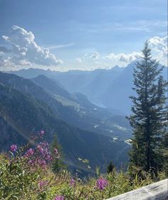 a bench on top of a mountain overlooking the valley and mountains in the back ground