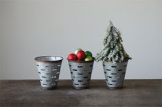 three metal cups with christmas decorations in them