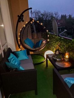 a patio with two chairs and a hammock hanging from the ceiling