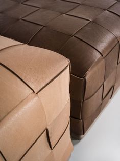 a close up of a brown and tan leather bench with woven squares on the back