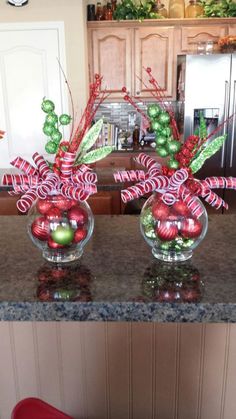 three glass vases filled with candy canes on top of a granite countertop