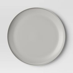 an empty white plate is shown on a plain surface with no one around it,