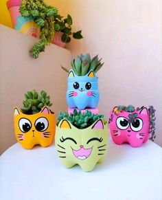 three small pots with plants in them on top of a white table next to a potted plant