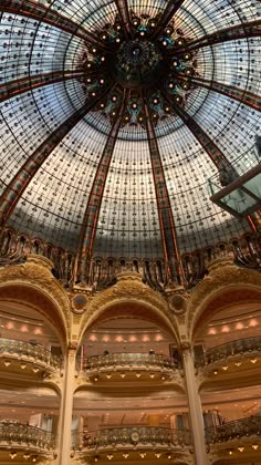 the inside of a large building with a glass dome and chandelier above it