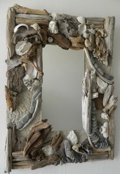 a mirror made out of driftwood and shells