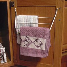 a kitchen cabinet with two towels hanging from it