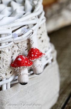 two red mushrooms sitting on top of each other in front of a white net bag