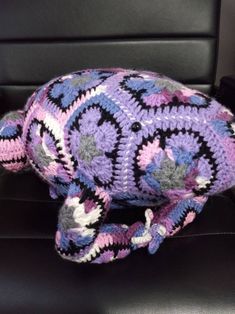 a crocheted stuffed animal sitting on top of a black chair