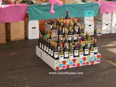 there are many bottles of wine on display at this outdoor vendor's market stall