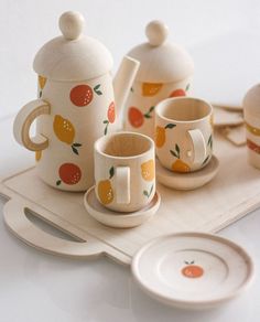 the tea set is decorated with oranges and lemons on it's tray