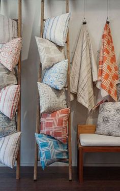 several different colored pillows hanging on a wall