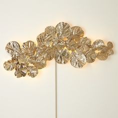 The Fiddle Fig Lighted Wall Decor is a stunning piece of illuminated wall art, meticulously crafted from brass with a gleaming shiny brass finish. Inspired by the graceful fiddle leaf fig, it brings nature's beauty into your space with radiant charm. Dimensions Overall 68"W x 26"H x 7"D (34 lbs) Cord Cover 32"H  Holds 18 1.5 Watt G4 Bulbs included Shiny Brass Dust with a soft, dry cloth UL Listed Illuminated Wall Art, Outdoor Umbrella Stand, Fiddle Fig, Ship Decor, Cord Cover, Fiddle Leaf, Global Views, Fiddle Leaf Fig, Candle Diffuser