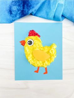 a paper plate with a chicken made out of construction paper on top of a blue background