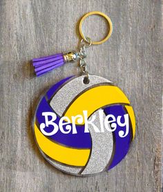 a keychain with a volleyball ball and tassel on it that says berkley