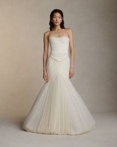 a woman in a white wedding dress posing for the camera