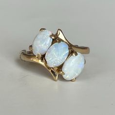 Vintage 14K Three Stone Opal Ring, 3.0 grams, Size 3, October Birthstone  Beautiful triple oval cut Opal ring in 14K yellow gold setting and spacer. Actual ring size may be larger. Weight: 3.0 grams Size: 3 Stone: Opal Color Stone: White Transparent Size Stone: ca. 6mm x 4mm Markings: 14K, symbol Band Width: 1.8mm Tested: Presidium Gemtester ll, Niton DXL Thermo Scientific Metal Analyzer, This was weighed on an Ohaus Scout® Jewelry Scale (testing performed by 3rd party) Condition: Very good preo White Oval Cluster Ring Hallmarked, Oval White Cluster Ring Hallmarked, Classic Three Stone Oval Opal Ring, Oval White Cluster Ring, Gold Marquise Three Stone Ring, Classic Oval Three Stone Cluster Ring, Oval Three-stone Opal Ring, Oval Three Stone Opal Ring, White Oval Opal Ring In 14k Gold