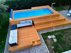 an above ground pool surrounded by wooden decking and lounge chairs with built - in seating