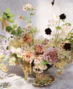 a vase filled with lots of flowers on top of a table