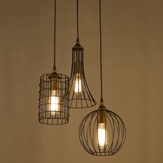 three light fixtures hanging from the ceiling with caged wire around them and one bulb turned on