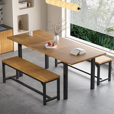 a dining table with two benches and a bowl of fruit on the plate next to it