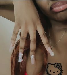 a woman with hello kitty nail decals on her chest and hand over her shoulder