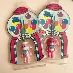 two plastic key chains in the shape of gummy bears and a gumball machine