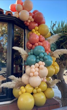 a bunch of balloons hanging from the side of a building