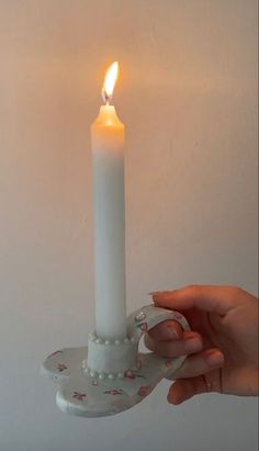 a person holding a lit candle in their hand