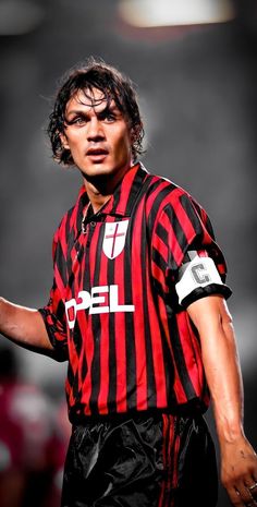 a soccer player is wearing a red and black striped shirt with white letters on it