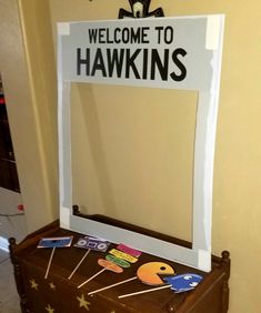 a welcome sign is placed on top of an old suitcase