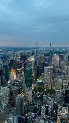 an aerial view of the city skyline at night with skyscrapers and other tall buildings