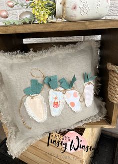 an embroidered pillow with three strawberries on the front and two hearts on the back