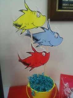 there are three fish on top of each other in the cupcakes stand next to some candy