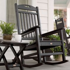 three rocking chairs sitting on the porch next to potted plants and a coffee table