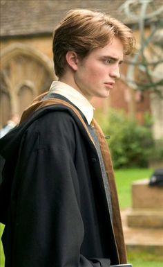 a young man with a book bag on his shoulder standing in front of a building