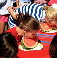 a group of people eating slices of watermelon