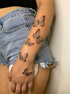 a woman's arm with butterflies tattooed on the left side of her right arm